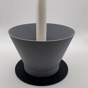 May include: A gray funnel with a white cylinder inside, sitting on a black circular base.