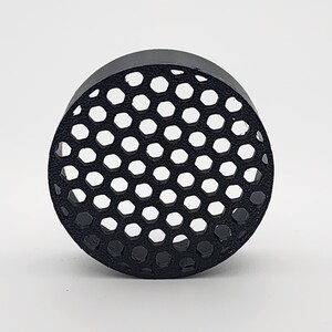 May include: Black round plastic filter with a honeycomb pattern.
