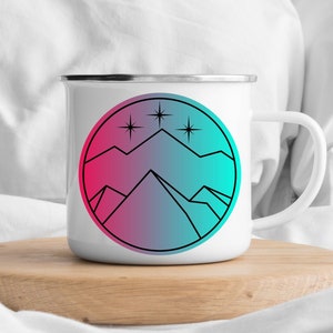 May include: White enamel mug with a black and white line drawing of mountains and stars on a pink and blue gradient background.