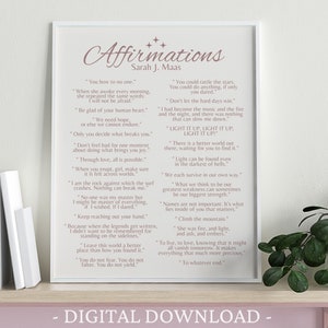 K&ouml;nnte beinhalten: Ein druckbarer digitaler Download eines rosa-wei&szlig;en Posters mit dem Titel "Affirmations" und einer Liste inspirierender Zitate von Sarah J. Maas. Das Poster ist gerahmt und steht auf einem Regal mit B&uuml;chern und einer Pflanze.