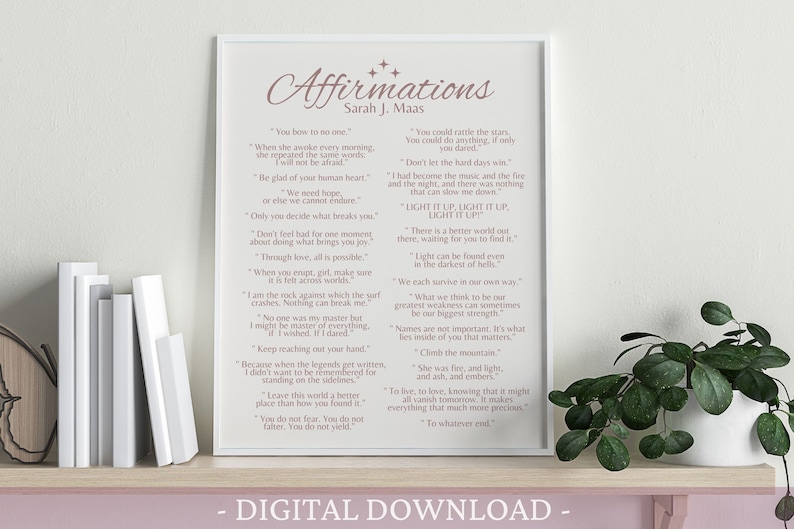 K&ouml;nnte beinhalten: Ein druckbarer digitaler Download eines rosa-wei&szlig;en Posters mit dem Titel "Affirmations" und einer Liste inspirierender Zitate von Sarah J. Maas. Das Poster ist gerahmt und steht auf einem Regal mit B&uuml;chern und einer Pflanze.