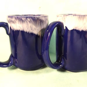 2 large pottery mugs ( 400ml ) capacity each .glazed in cobalt blue with a white rim