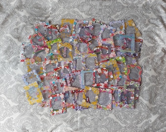 May include: A collection of numerous rectangular plastic photo frames, each featuring a unique arrangement of colorful decorative stickers, including patterns of fruits, flowers, hearts, stars, and geometric shapes in various vibrant colors.