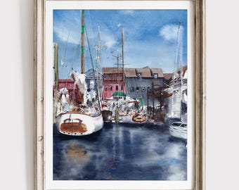 May include: A framed watercolor painting depicting a harbor scene with several sailboats moored in dark blue water. The background features red and grey buildings under a bright blue sky. The artwork is enclosed in a light-colored wooden frame.