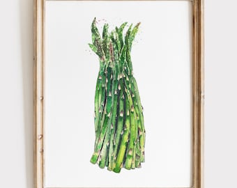 May include: A watercolor painting of a bunch of green asparagus spears with purple-tipped heads, rendered in shades of vibrant green and dark forest green, displayed inside a light-toned wooden frame against a plain white background.