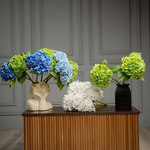Customized wedding reception floral centerpiece featuring artificial hydrangeas, elevating bridal table decor with faux beauty.