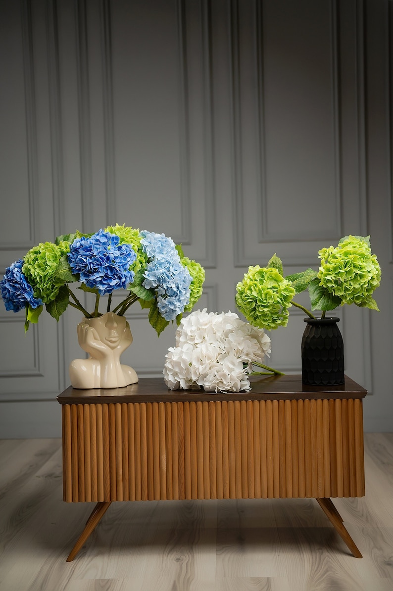 Customized wedding reception floral centerpiece featuring artificial hydrangeas, elevating bridal table decor with faux beauty.