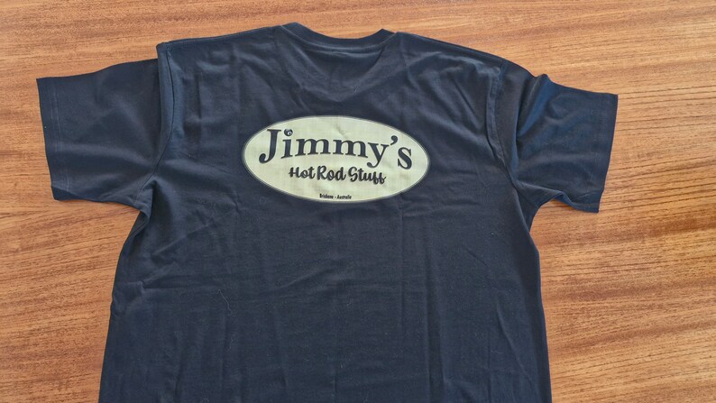 May include: A dark blue t-shirt with a white oval logo that says "Jimmy's Hot Rod Stuff" on the back.