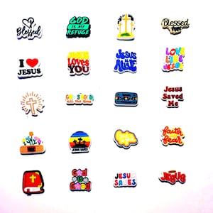 May include: A collection of colorful, religious-themed charms with various phrases and images, including "God is my Refuge", "Jesus Loves You", "Jesus is Alive", "Jesus Saved Me", "Faith over Fear", and "God is Good".