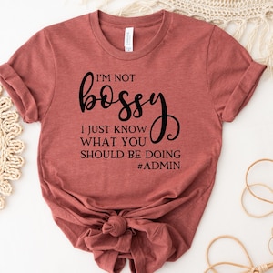 May include: A rust-colored t-shirt with the text "I'm not bossy, I just know what you should be doing #admin" printed in black.