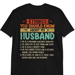 May include: Black t-shirt with a vintage-style graphic that says "5 Things You Should Know About My Husband" with a list of five reasons why he is awesome.