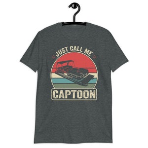 May include: A dark heather grey t-shirt with a vintage-style graphic of a pontoon boat and the text "Just Call Me Captoon".
