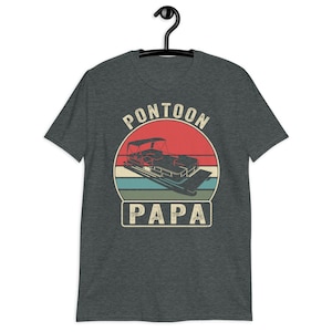 May include: A dark heather grey t-shirt with a vintage-style graphic of a pontoon boat and the text "Pontoon Papa".