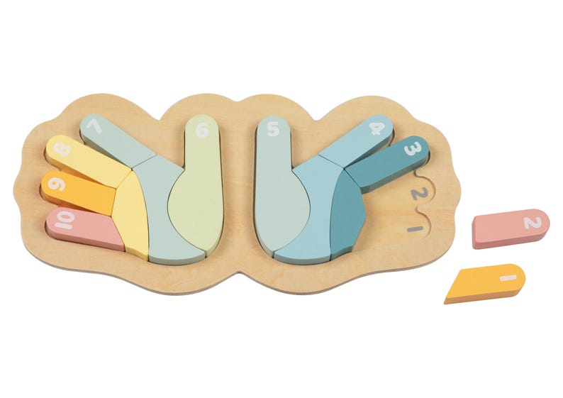 May include: A wooden puzzle shaped like two hands with numbers 1-10 on each finger. The puzzle pieces are in pastel colors and are missing from the puzzle. The puzzle pieces are on a white background.