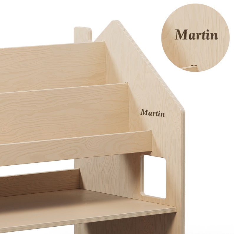 May include: A light wood bookshelf shaped like a house with three shelves and a cutout window. The name "Martin" is engraved on the side of the bookshelf.