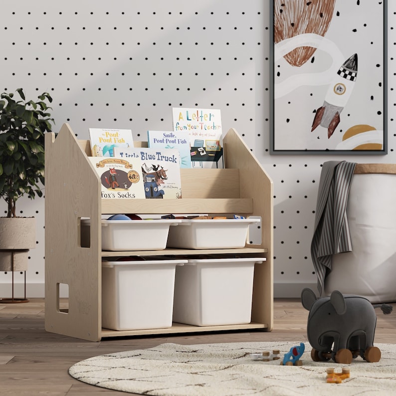 May include: A wooden bookshelf with a house-shaped design, featuring four white storage bins and a shelf for books. The bookshelf is filled with children's books with titles like "Pout-Pout Fish", "Smile. Pout-Pout Fish", "Little Blue Truck", and "Fox's Socks".