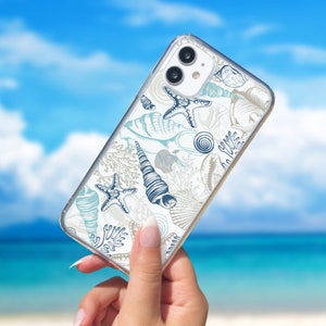 Puede incluir: Una funda transparente para teléfono con fondo blanco y un patrón de conchas y estrellas de mar azules y blancas.