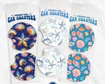 Può includere: Set di sei sottobicchieri per auto con un design a conchiglie e stelle marine. I sottobicchieri sono stampati con uno schema di colori blu, bianco e rosa. Il testo "COCONUT GIRL CAR COASTERS" è stampato sulla confezione.