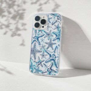 May include: A clear phone case with a white background and a blue and white starfish pattern. The case has a cutout for the camera lens.
