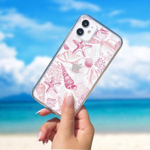 Pu&ograve; includere: Una custodia per telefono trasparente con un designo di conchiglie e stelle marine rosa e bianche. La custodia &egrave; progettata per un iPhone.