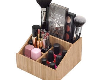 May include: A light brown bamboo makeup organiser with multiple compartments containing various cosmetics, including makeup brushes, lipstick tubes, nail polish bottles, and two rectangular eyeshadow palettes, one labelled Urban Decay.