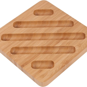 Puede incluir: Una bandeja de servir de madera natural con cinco ranuras rectangulares. La bandeja está hecha de bambú y tiene un color marrón claro.
