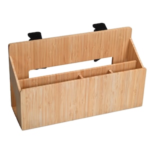 Puede incluir: Un organizador de escritorio de bambú con múltiples compartimentos y un asa. El organizador tiene un acabado natural de vetas de madera y clips negros para la fijación. Está diseñado para guardar material de oficina y mantener un escritorio ordenado.