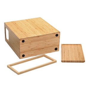 May include: A wooden bread box with a removable lid and a separate tray. The box is made of natural bamboo and has a light brown color.