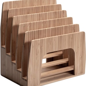 Puede incluir: Un organizador de escritorio de bamb&uacute; con m&uacute;ltiples ranuras para guardar archivos, papeles u otros suministros de oficina. El organizador tiene un dise&ntilde;o escalonado, con cada ranura ligeramente m&aacute;s baja que la que est&aacute; detr&aacute;s. La veta natural de la madera es visible.