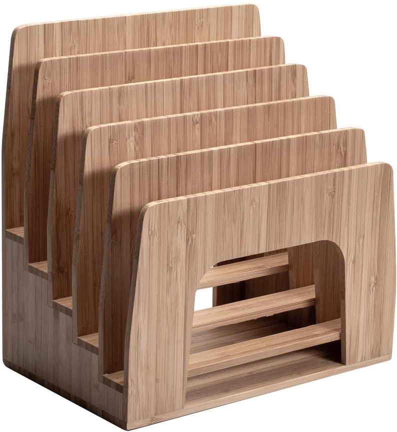 Puede incluir: Un organizador de escritorio de bamb&uacute; con m&uacute;ltiples ranuras para guardar archivos, papeles u otros suministros de oficina. El organizador tiene un dise&ntilde;o escalonado, con cada ranura ligeramente m&aacute;s baja que la que est&aacute; detr&aacute;s. La veta natural de la madera es visible.