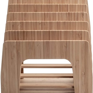 Puede incluir: Un organizador de escritorio de bamb&uacute; con m&uacute;ltiples ranuras para guardar archivos, papeles u otros suministros de oficina. El organizador tiene un acabado de vetas de madera natural y una construcci&oacute;n robusta.