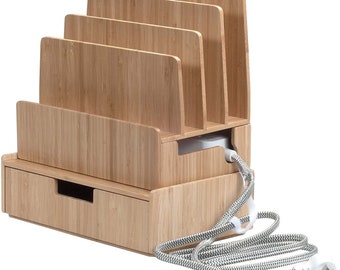 May include: Bamboo charging station with a drawer and slots for multiple devices. The charging station has a white power cord with a black and white striped cord cover. "Power Strip not Included" is written below the charging station.