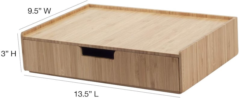 Może przedstawiać: Bambusowy organizer biurkowy z szufladą. Organizer ma 34,3 cm długości, 24,1 cm szerokości i 7,6 cm wysokości. Szuflada ma wycięty uchwyt. Bambus ma jasnobrązowy kolor.