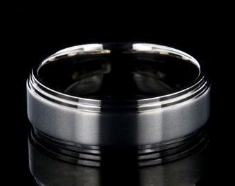May include: A silver wedding band with a brushed finish and a grooved edge.