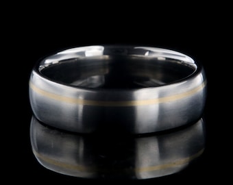 May include: A silver wedding band with a thin gold inlay.