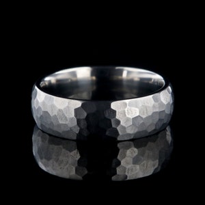 May include: A silver hammered wedding band with a textured finish.