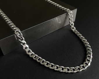 Op de afbeelding: Een zilveren curb chain ketting met een klassiek ontwerp. De ketting is gemaakt van metaal en heeft een glanzende afwerking.