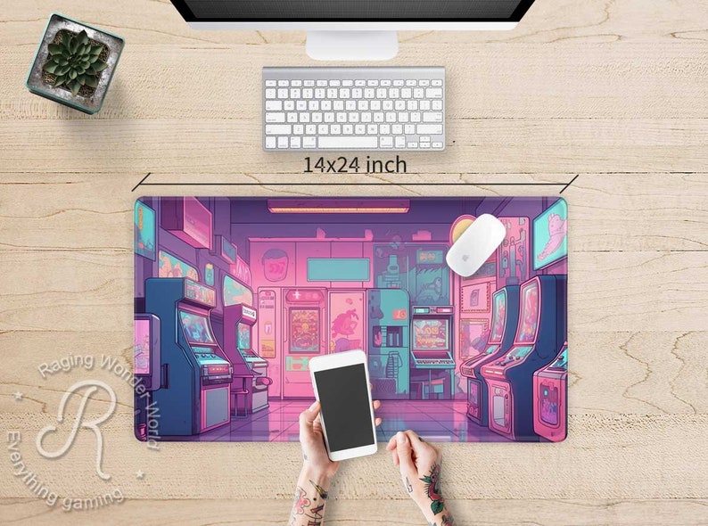 May include: A 14x24 inch gaming mouse pad featuring a colorful illustration of an arcade with retro game machines in shades of pink, blue, and purple. A white mouse and keyboard are on the wooden desk.