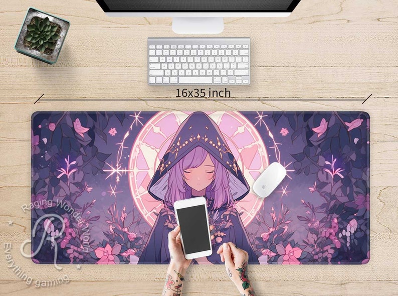 May include: A purple and pink anime-style mouse mat featuring a girl wearing a hooded cloak and holding a smartphone. The mouse mat has a floral design and a circular pattern with stars. The text "Raging Wonder World" is visible on the mouse mat.