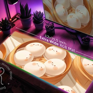 May include: A 12x35.5 inch extra wide RGB gaming mousepad with a cute design of steamed buns with faces in bamboo baskets. The mousepad has a rainbow border and the text "Raging Wonder World Everything gaming" in the bottom left corner.