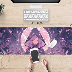 May include: A purple and pink anime-style mouse mat featuring a girl wearing a hooded cloak and a floral design. The mouse mat is 12x31 inches.