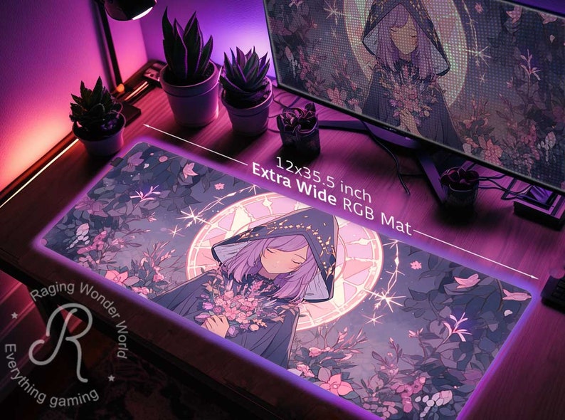 May include: A purple and pink anime-style mouse mat featuring a girl in a hooded cloak holding flowers. The mouse mat is 12x35.5 inches and says "Extra Wide RGB Mat". The text "Raging Wonder World Everything gaming" is in the bottom left corner.