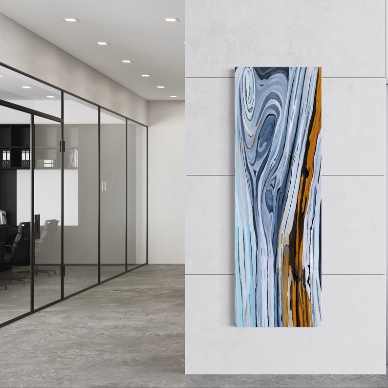 May include: Abstract wall art featuring a blue, white, and gold swirling pattern. The artwork is framed and hanging on a white wall.