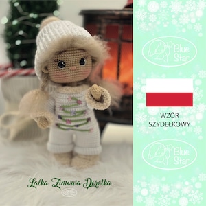 May include: A crocheted doll wearing a white hat and a white outfit with a green Christmas tree design. The doll is standing on a white surface. The image also includes a Polish flag and the text "Wzor Szydelkowy" which means "Crochet Pattern" in Polish.