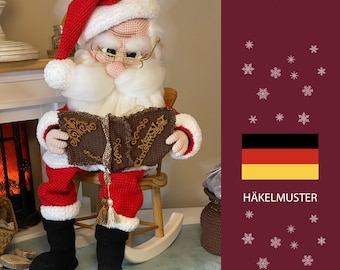 May include: A crocheted Santa Claus doll wearing a red hat, glasses, and a white beard, reading a book with "Merry Christmas" on the cover. The doll is seated on a wooden rocking chair. The doll is wearing a red suit with black boots.