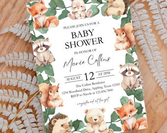 May include: A baby shower invitation with a woodland theme. The invitation features a white background with a green leafy border. There are various woodland animals, including a fox, a rabbit, a hedgehog, a raccoon, a squirrel, a bear, and a deer. The text on the invitation reads "Please join us for a baby shower in honor of Marie Collins, August 12 at 2 PM, The Collins Residence, 1234 Woodland Drive, Appling, Texas 12345, RSVP to Nicole at 123.456.7890, registered at target."