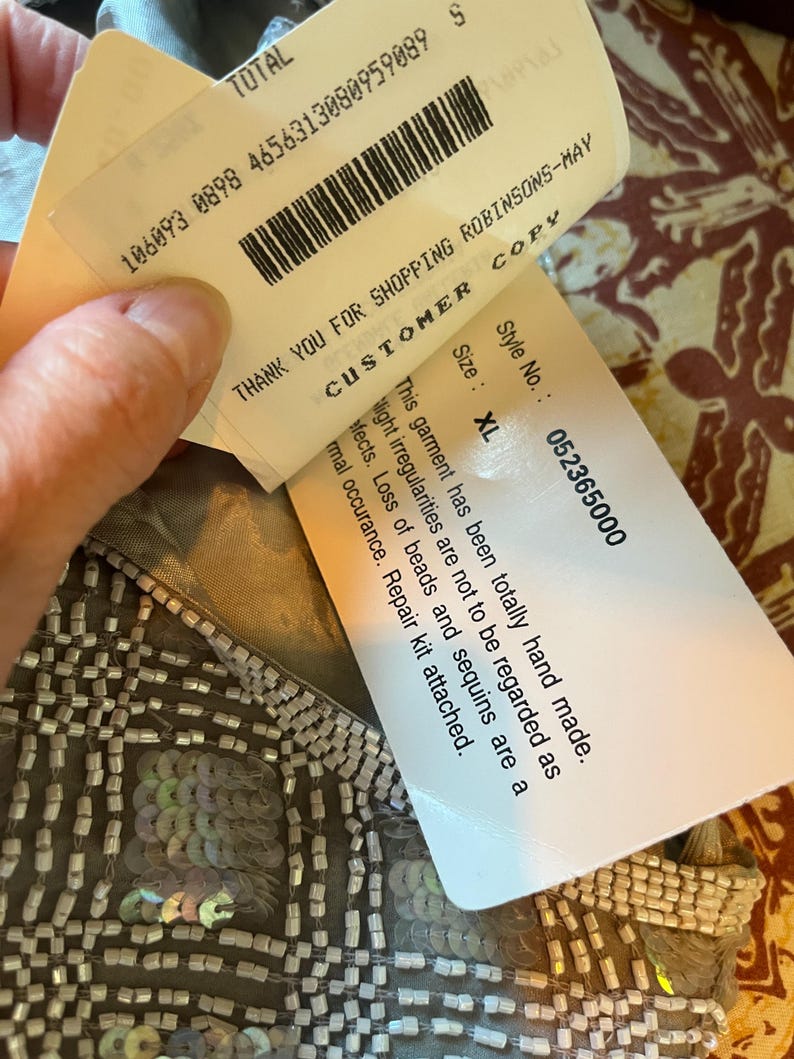 Puede incluir: Primer plano de una prenda hecha a mano con detalles de cuentas y lentejuelas. El dise&ntilde;o presenta un patr&oacute;n de cuadr&iacute;cula con lentejuelas iridiscentes. Las etiquetas adjuntas dicen "GRACIAS POR COMPRAR EN ROBINSONS-MAY" y "Talla: XL".