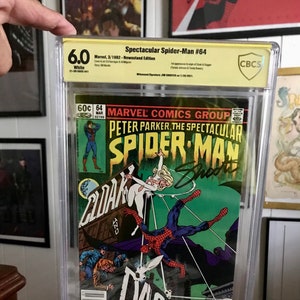 Puede incluir: Un cómic clasificado en una caja de plástico. El cómic se titula "Peter Parker, The Spectacular Spider-Man" y presenta un fondo verde con Spider-Man balanceándose en el aire. El cómic está clasificado con un 6.0 por CBCS.