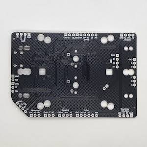 Puede incluir: Una placa de circuito impreso negra con varios componentes, incluyendo un joystick, una barra t&aacute;ctil, un D-pad y una barra Whammy. La placa tiene etiquetas para GND, 5V, VCC, A1, A2, SCL, SDA, ST, SEL, ON, UP, RT, LT, HM, TLT, D, CI, SV, B, Y, R, G y Auth.