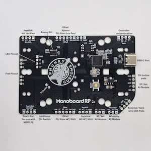 Puede incluir: Una placa de circuito impreso negra con el texto "Monoboard RP 2.2" impreso en ella. La placa tiene varios componentes, incluyendo un puerto USB-C, un interruptor de inclinaci&oacute;n, una barra t&aacute;ctil y un joystick. La placa est&aacute; dise&ntilde;ada para su uso con consolas de videojuegos.